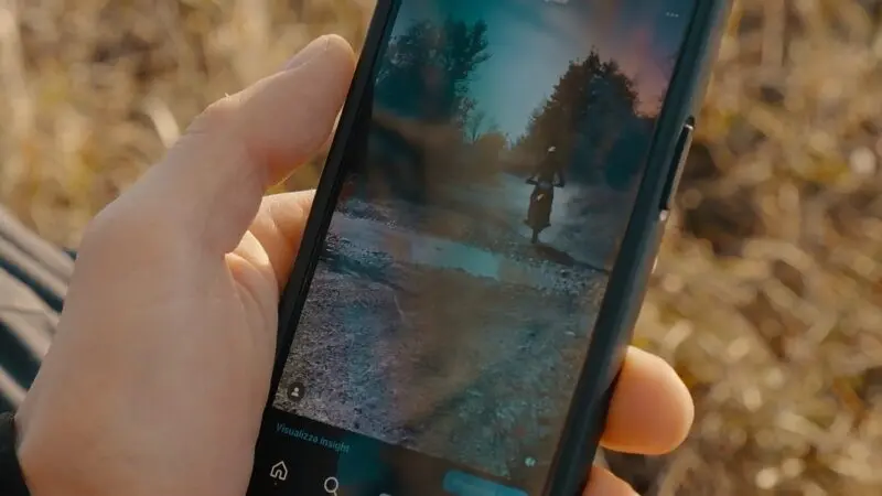 A close-up of a hand holding a smartphone displaying an Instagram Reel