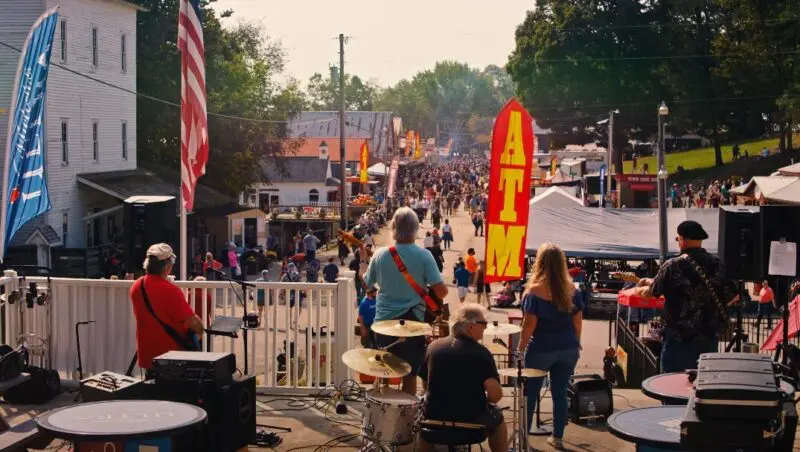 Lively street performers entertain a bustling crowd at a town fair